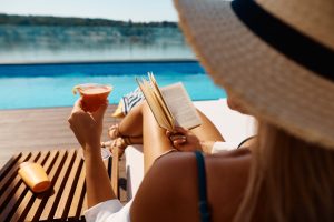 Close,Up,Of,Woman,Reading,Novel,While,Drinking,Summer,Cocktail